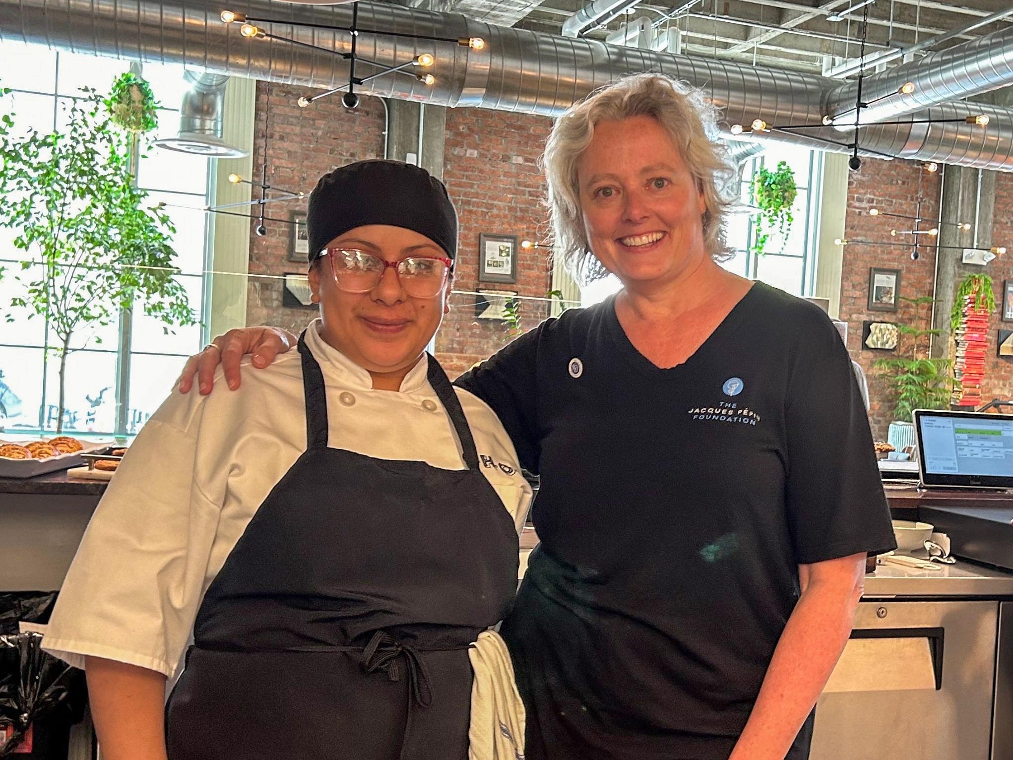Chefs in a conference room viewing a video stream featuring Jacuqes Pépin