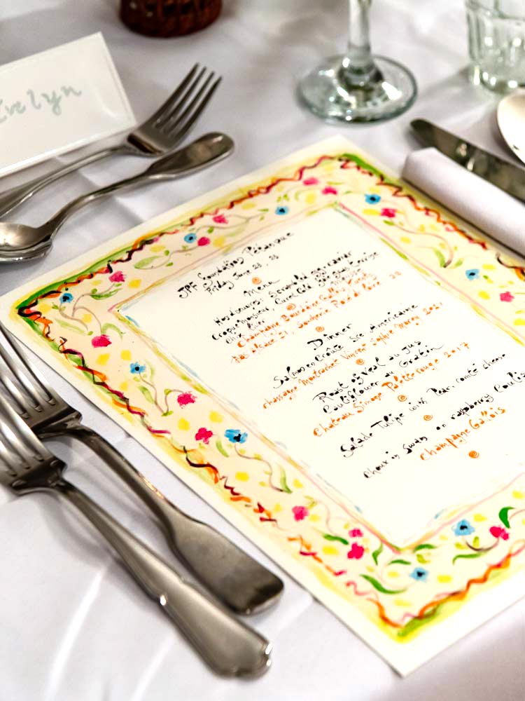 Image of a dinner table place setting with a painted menu