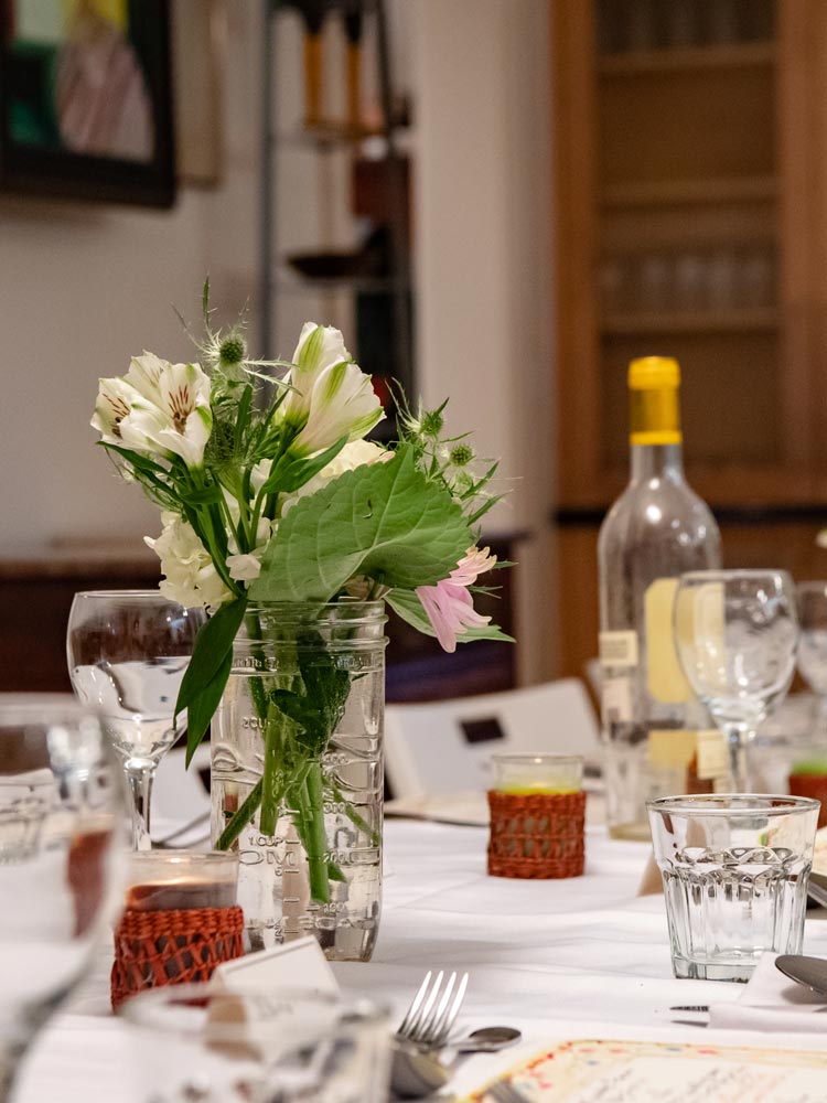 Image of a dinner table with flowers and a traditional place setting