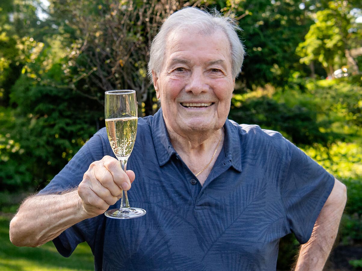 Jacques Pepin holding a champagne glass