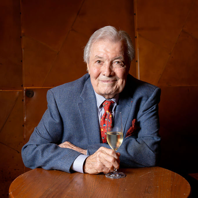 Jacques Pepin sitting with a glass of champagne. Photo by Eric Vitale Photography