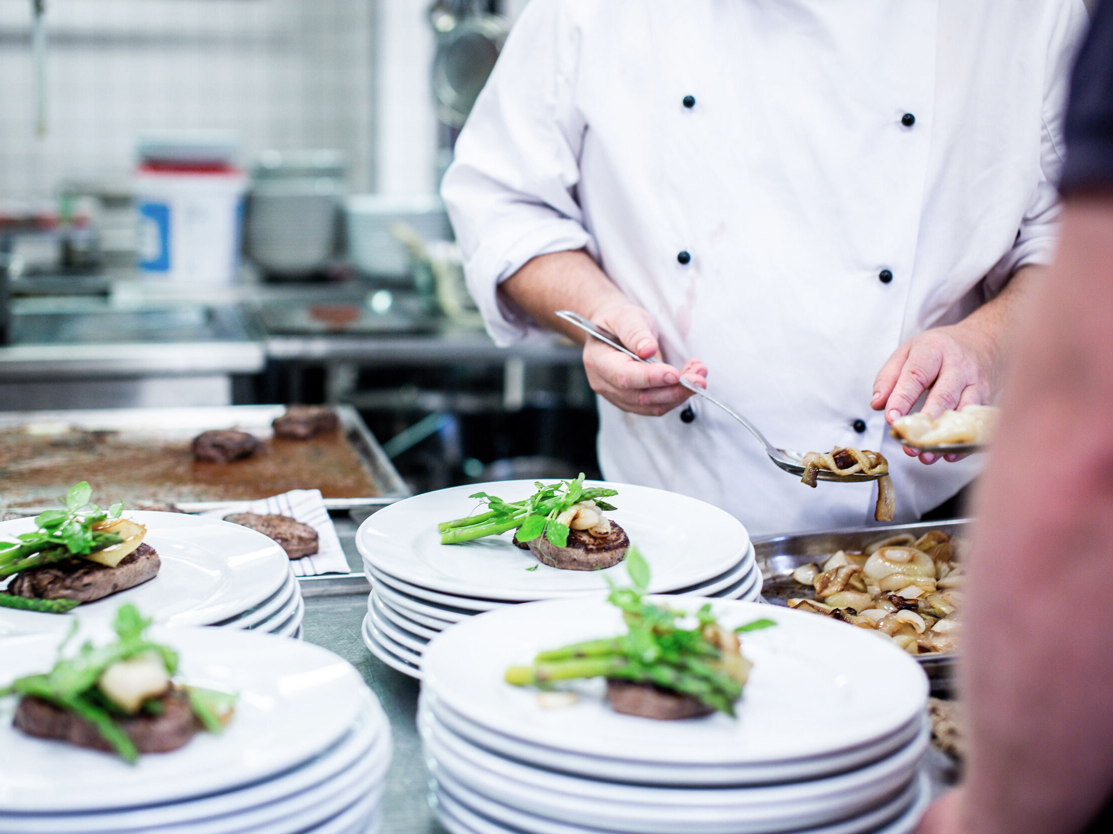 Culinary worker preparing plates of food