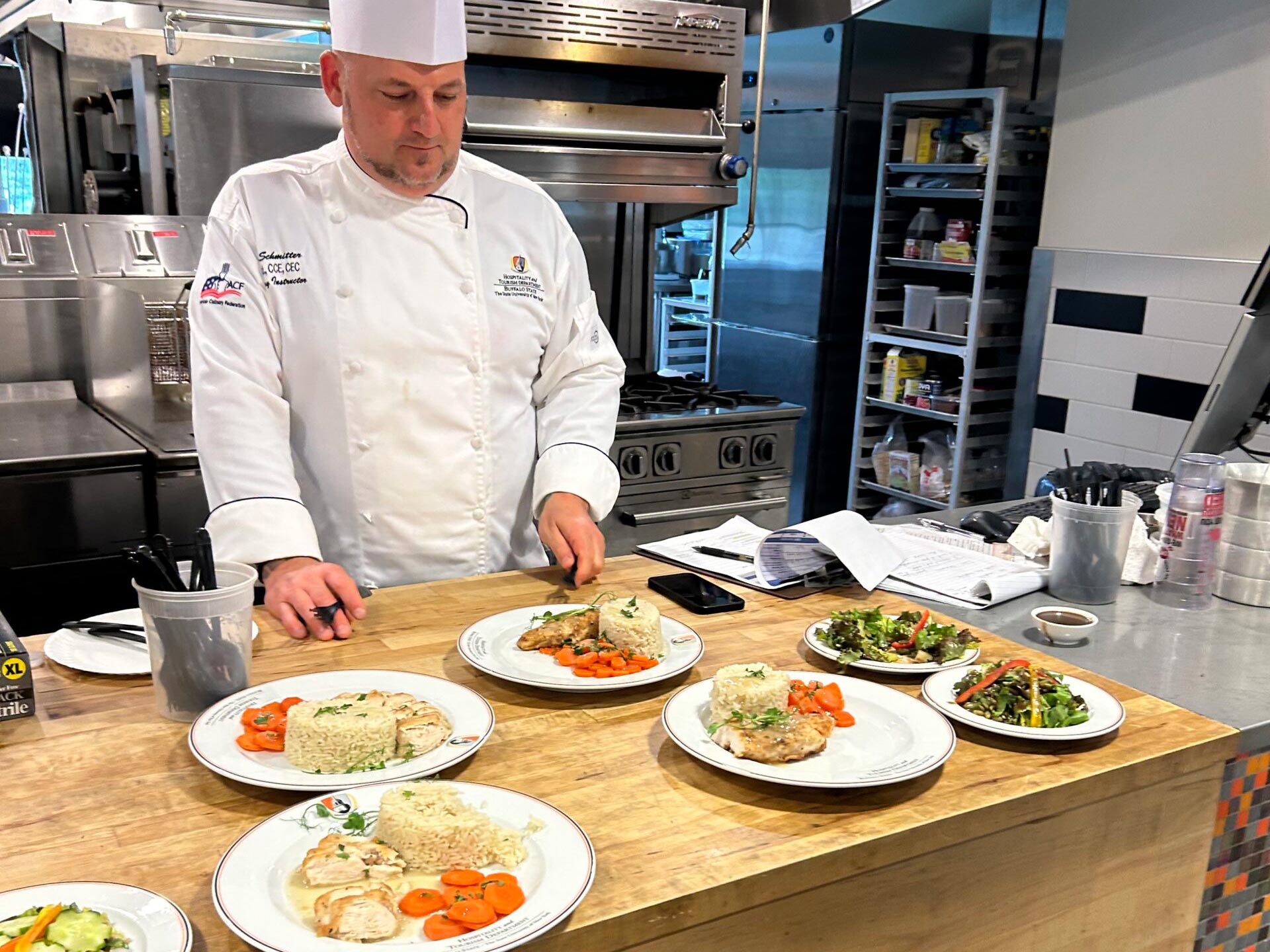 Chef in a kitchen with a set of dinner plates