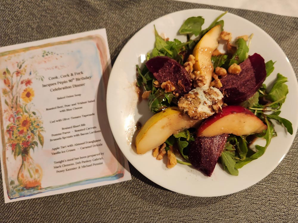 Plate with salad and a menu in the background